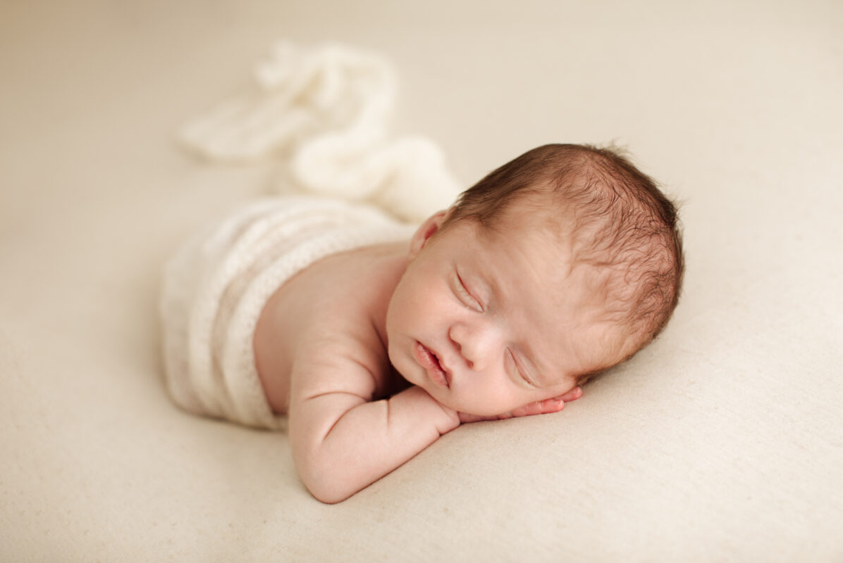 A newborn baby during a photoshoot showing you what to wear for a photoshoot